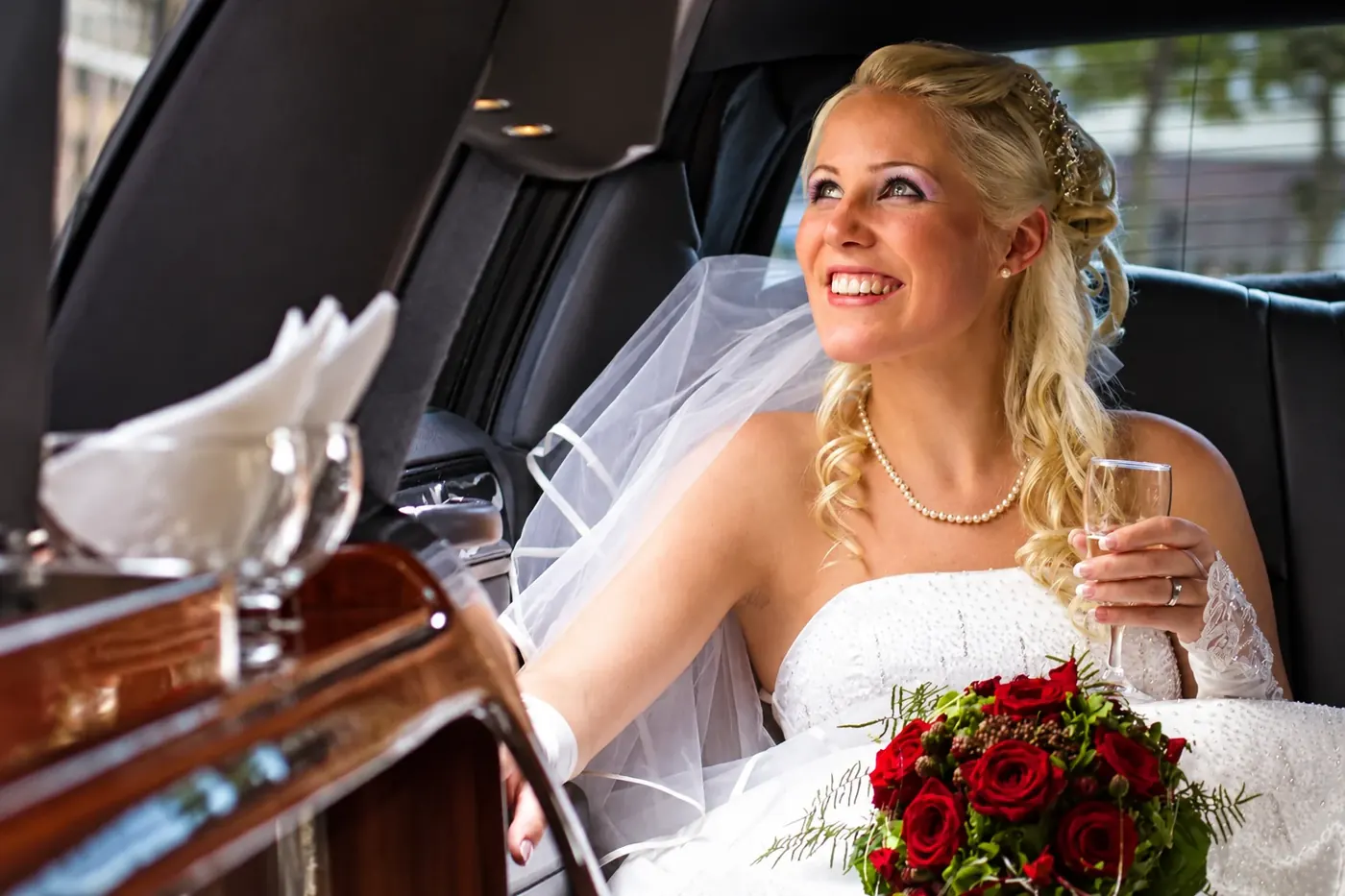 Braut mit Brautstrauß in der Silver Line Stretchlimousine